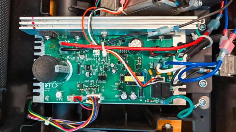 A treadmill motor control board, wired in place inside the motor compartment